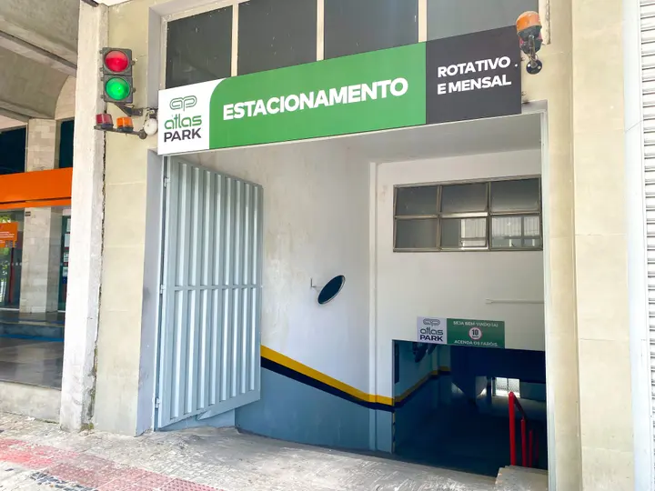 Entrada de estacionamento com placa Atlas Park: estacionamento rotativo e mensal